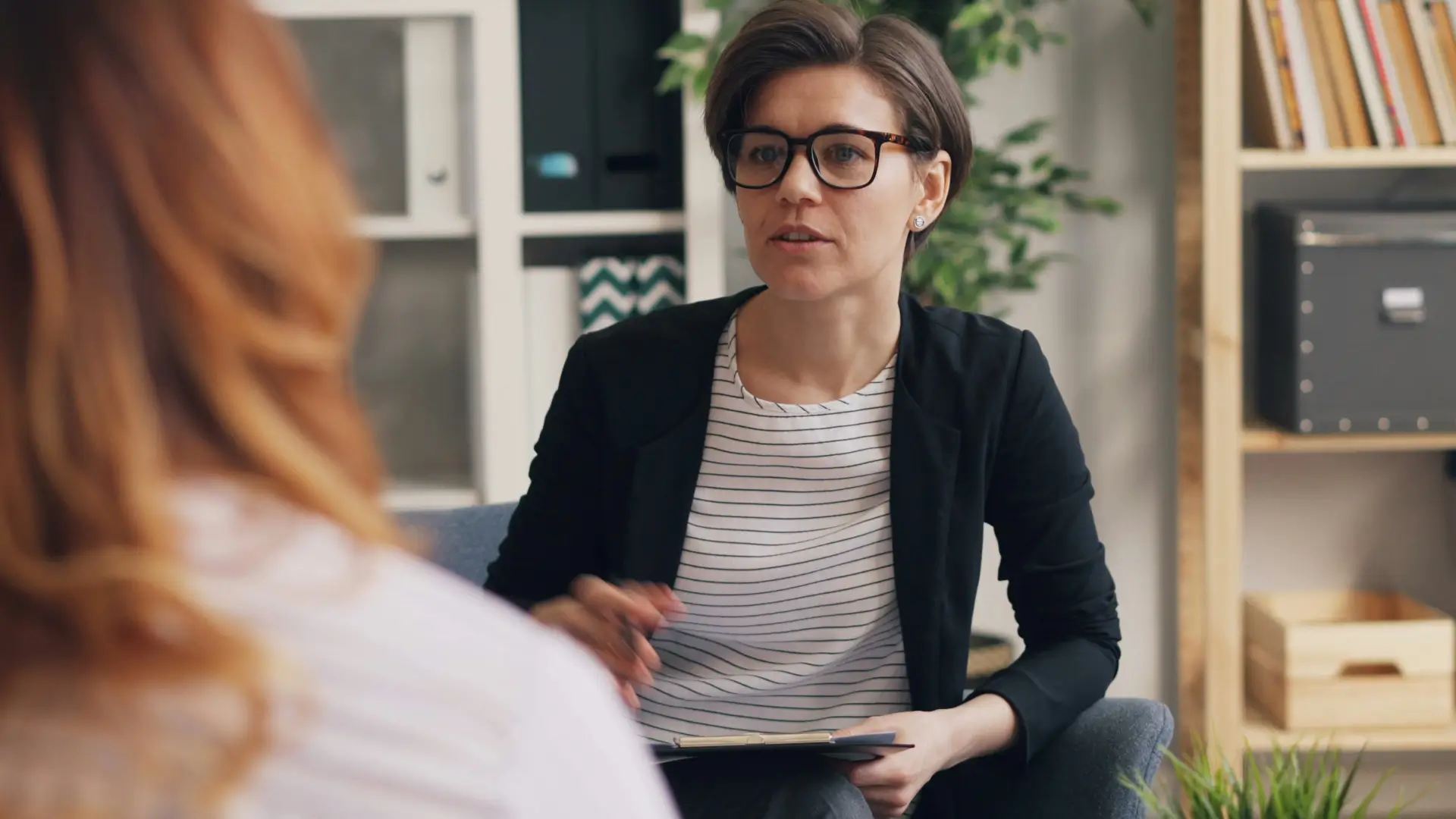 Two people in a candid one-on-one conversation at a desk