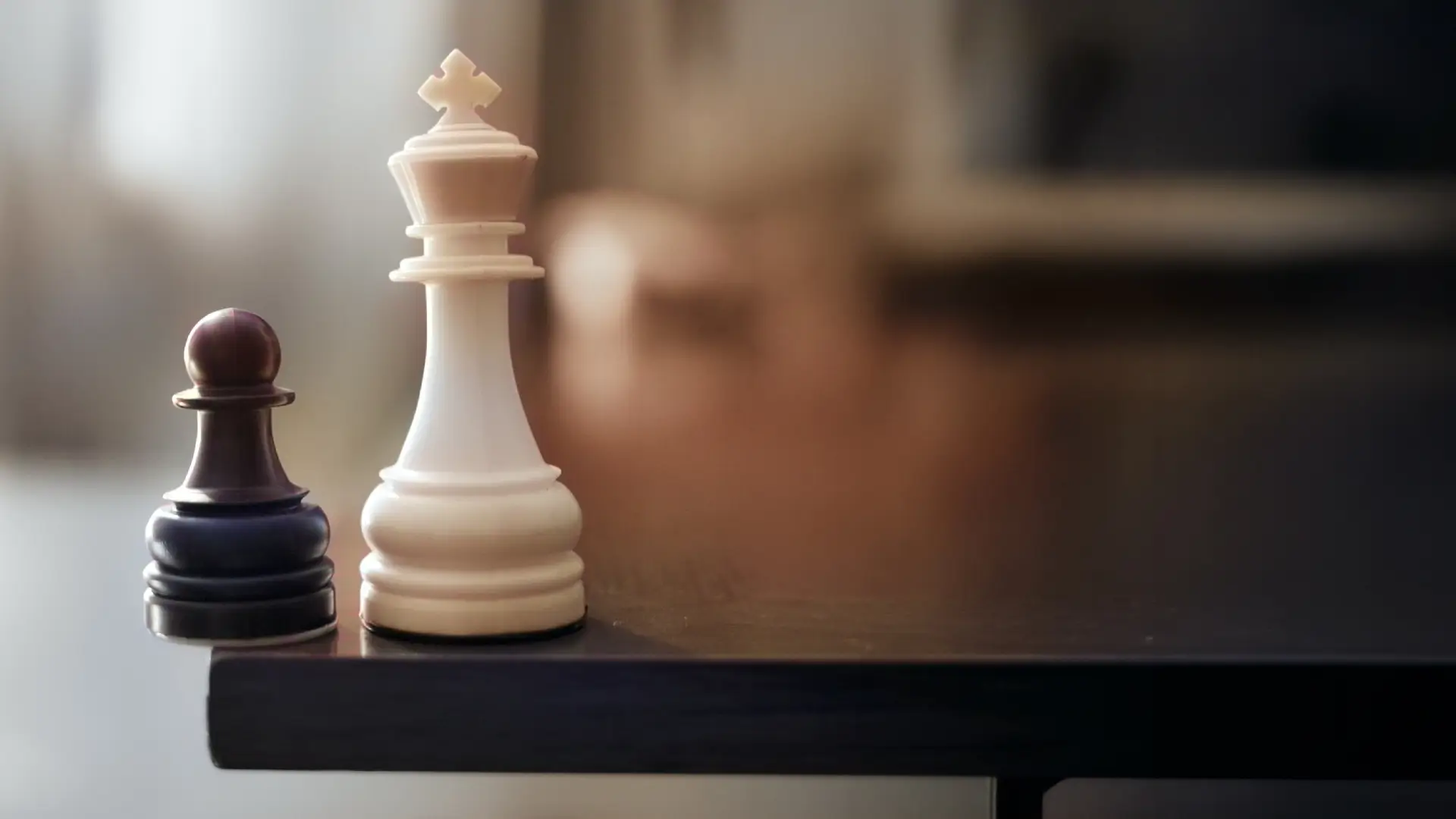 A chess king casting a shadow over a pawn